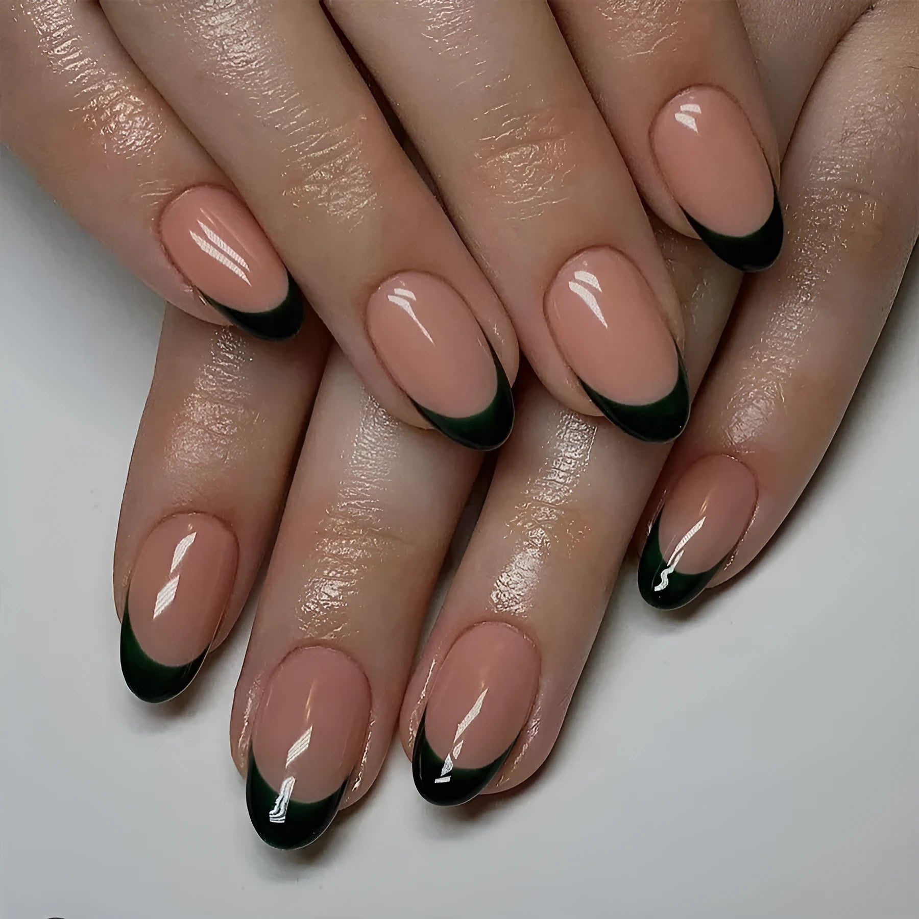 24 black French style acrylic false nails with short almond shape laid out on a surface.