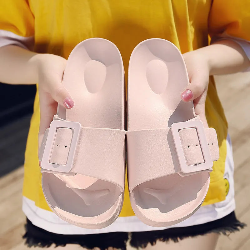 Women's grey blue EVA buckle slippers on a light background, showing the adjustable strap and textured sole.