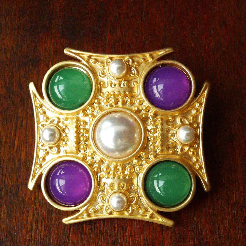 A vintage-style baroque brooch made of zinc alloy in a diamond shape on a fabric background.