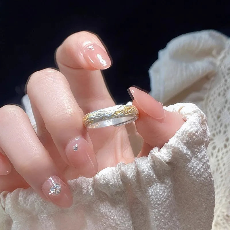 Open mouth silver and gold ring with a geometric Xiangyun pattern on a white copper band.