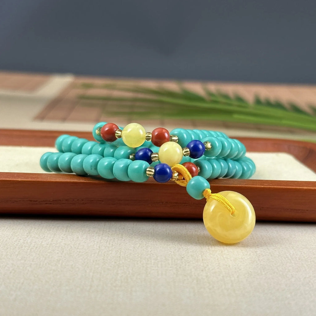 Hand-woven turquoise mesh flower lucky pendant on a ball bead necklace chain, adjustable length.
