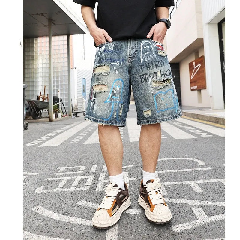 Blue ripped men's denim shorts with graffiti print and a zipper fly