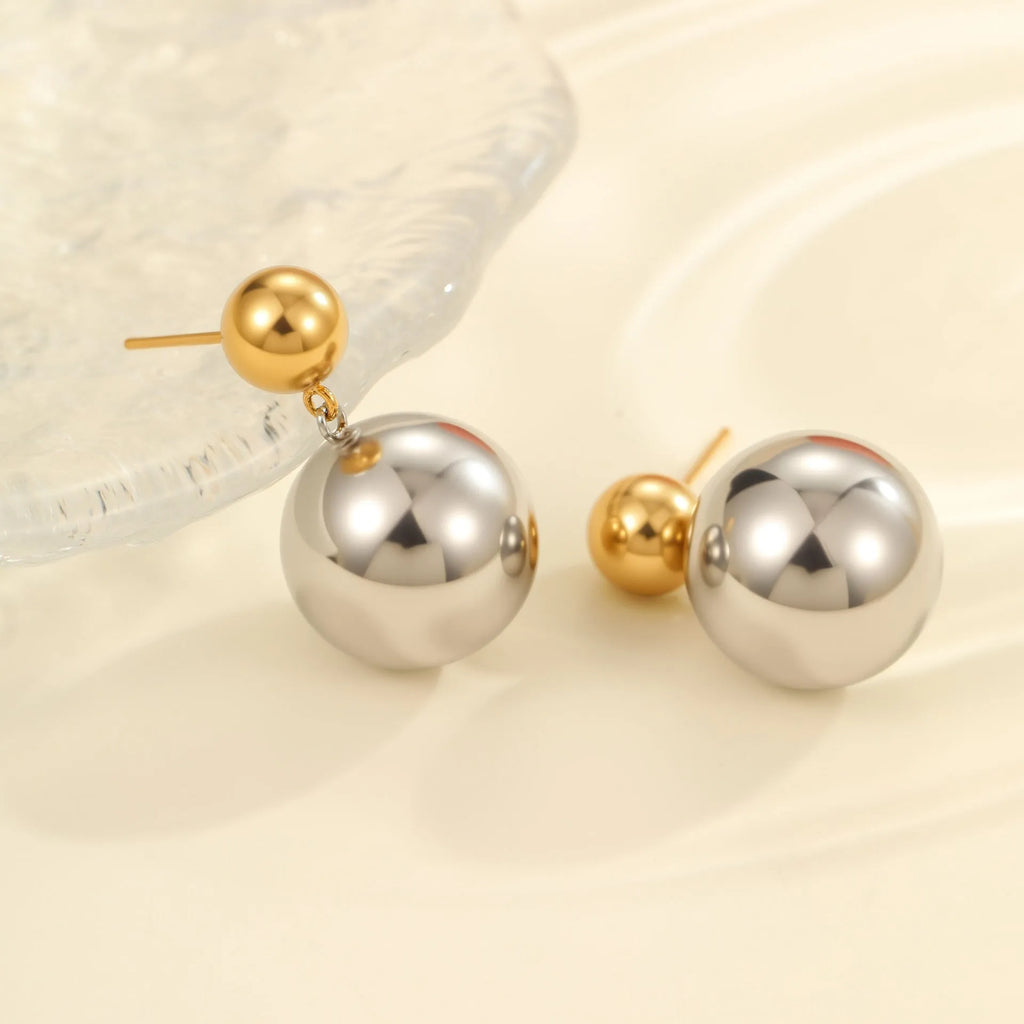 A pair of stainless steel stud earrings with 18K gold electroplated colour-block finish and round bead geometry design.
