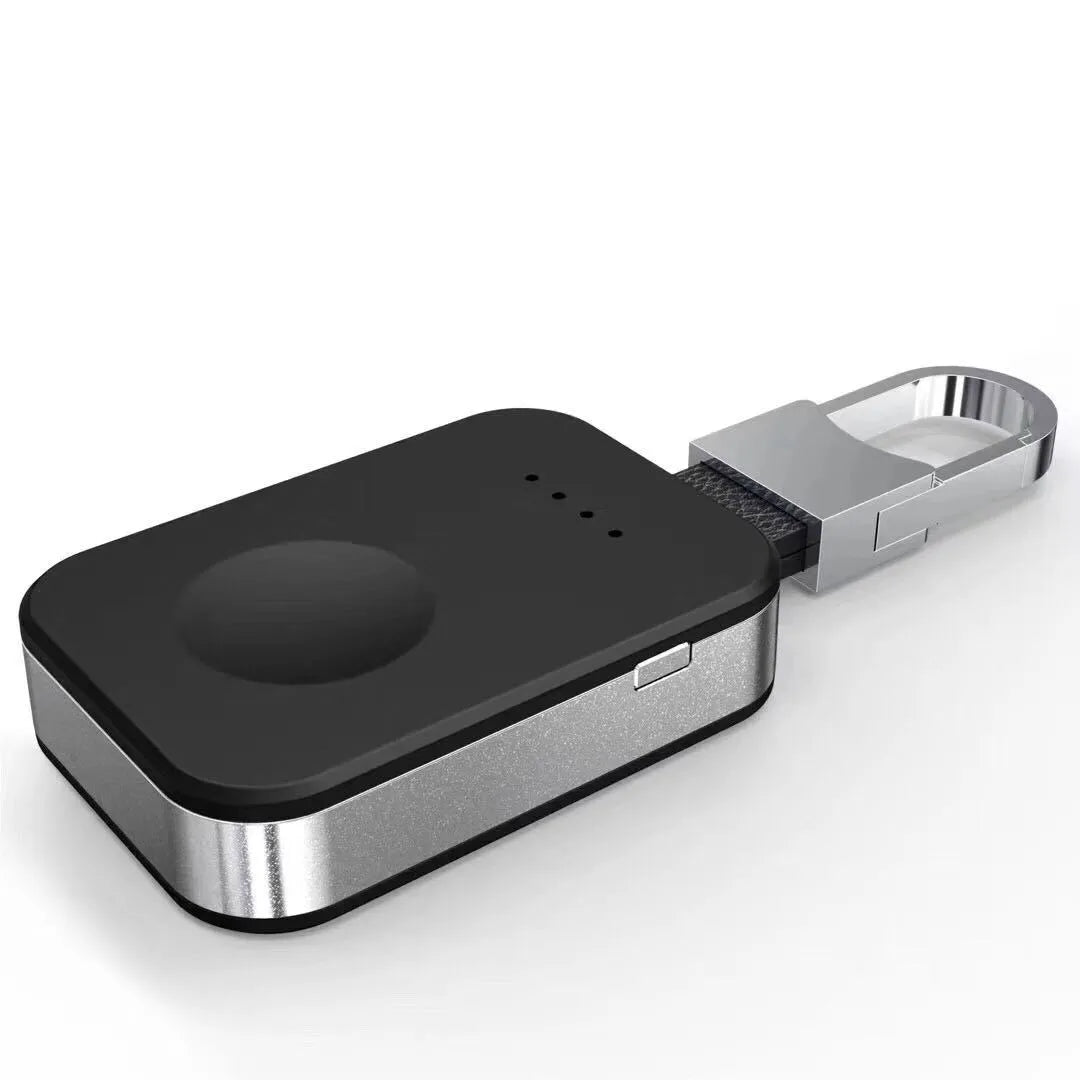 Black Apple Watch portable power bank keychain charger with USB port shown next to an Apple Watch.