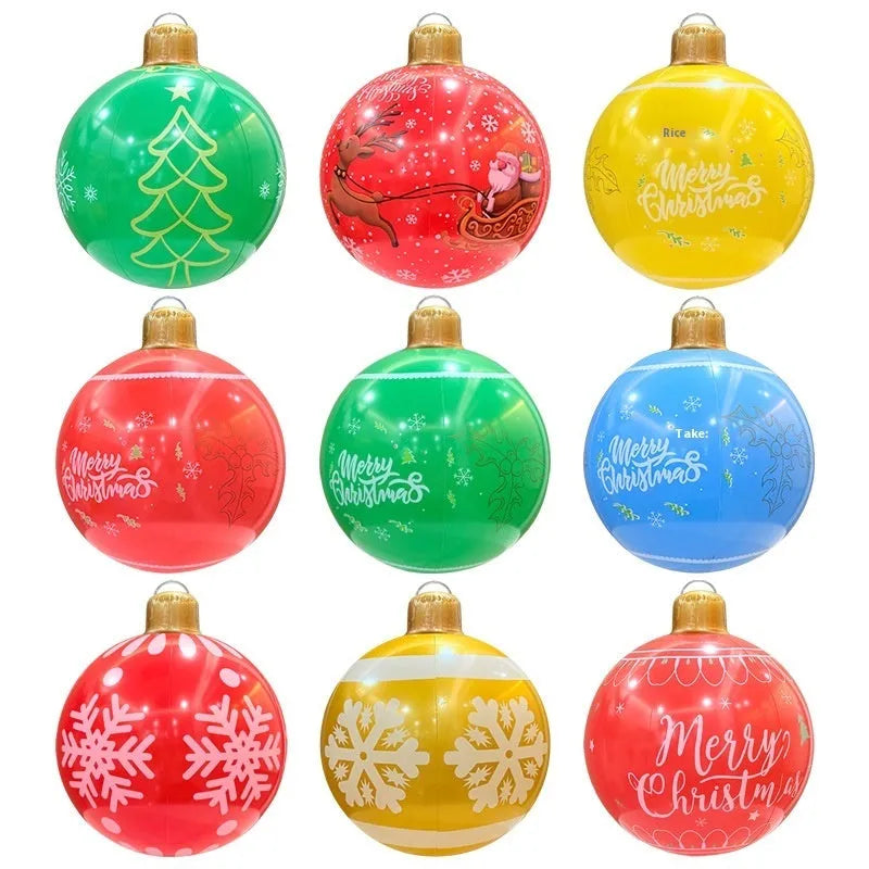 Large red inflatable Christmas ball with snowflake design and flashing LED lights in a garden.