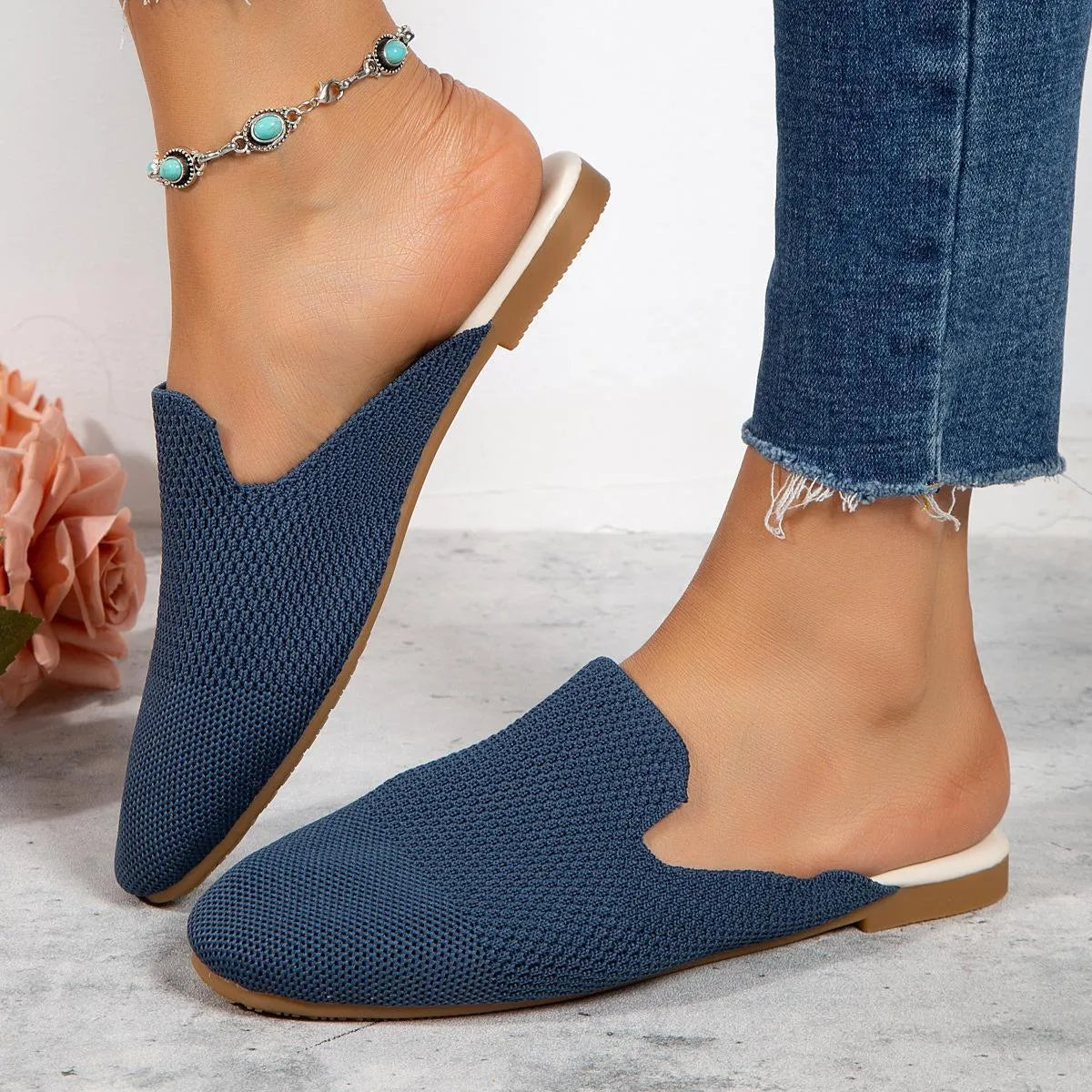 Apricot coloured mesh slip-on sandals with a round toe and flat rubber sole on a wooden floor.
