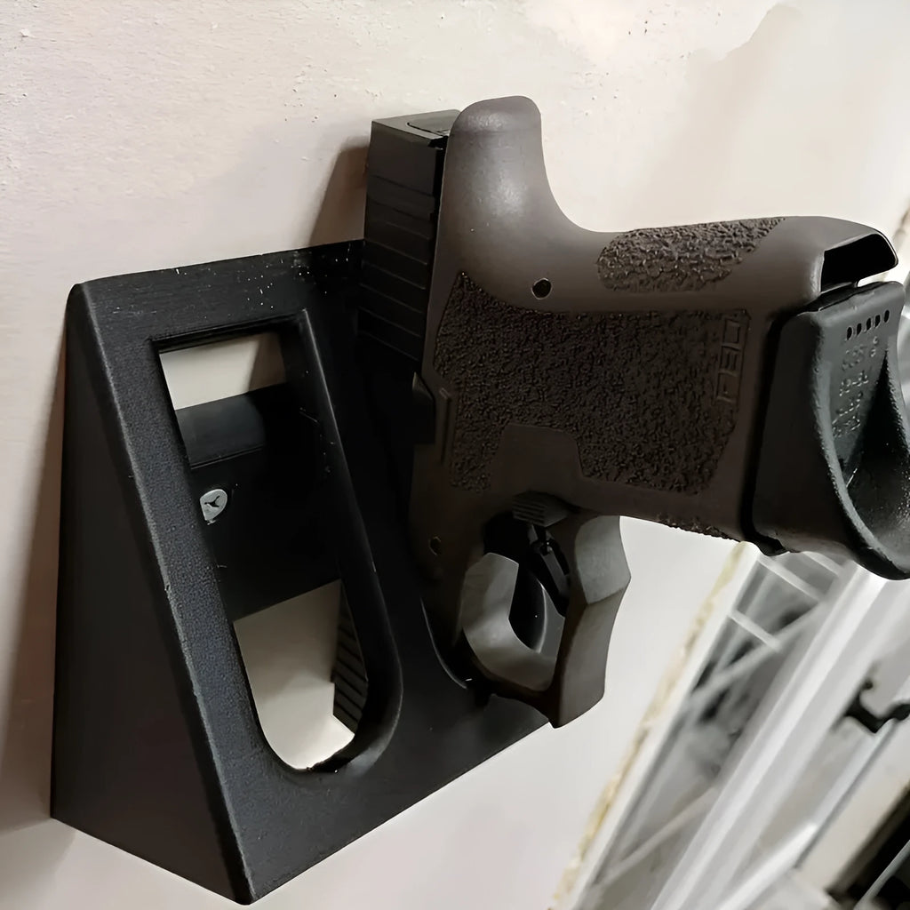 Black punk-style plastic pistol stand for airsoft and display models, measuring 10.85 by 7.6 cm.