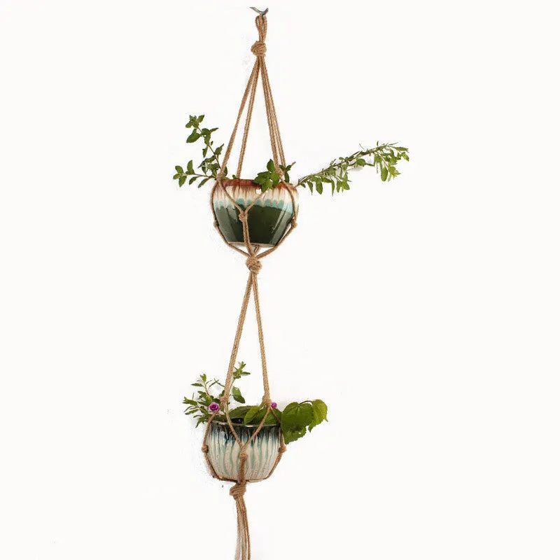 Woven cotton rope plant holder in a desktop style with greenery inside.