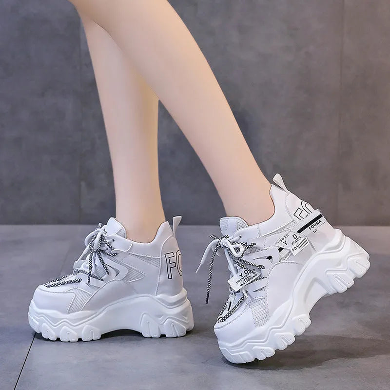 White and black women's low-top mesh platform sports shoes with cross strap and round toe.