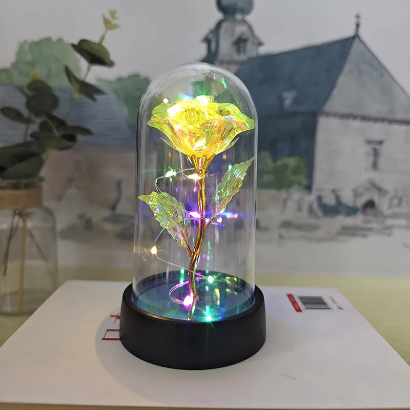 Small plastic night lamp with floral decoration and coloured light options on a black base.