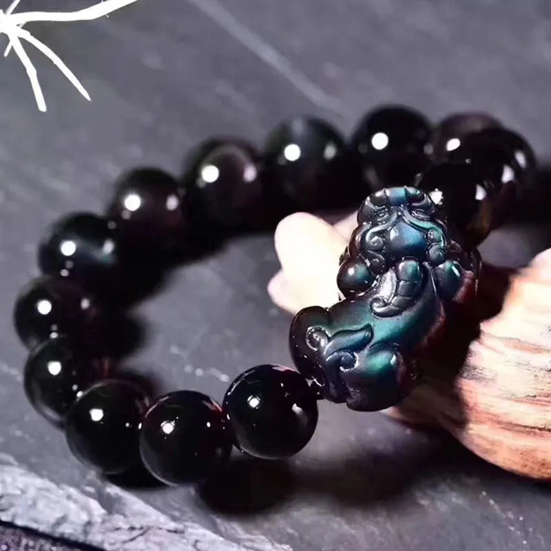 Polished natural ice colour Eye Obsidian crystal beads on an elasticated bracelet cord.