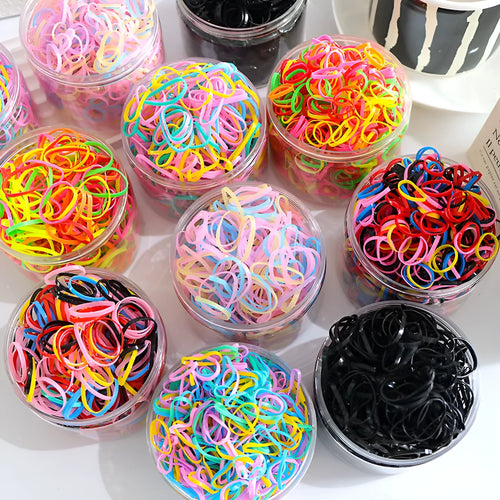 Pack of multicoloured thin TPU baby hair ties stored in a clear reusable plastic container.