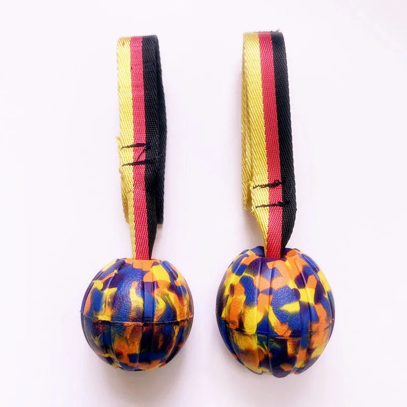 Camouflage and yellow floating EVA dog balls with tether strings in three different sizes on blue background.