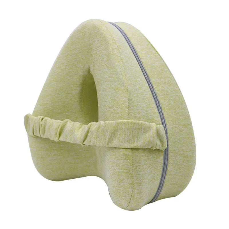 Love heart-shaped dark blue memory foam leg pillow for adults on a bed.