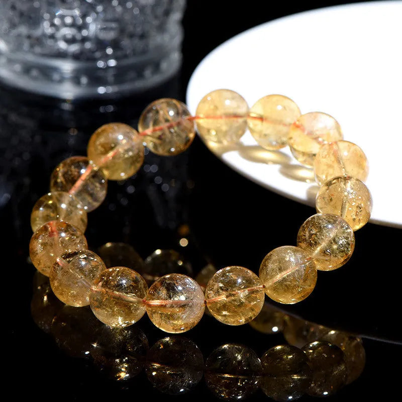 A natural yellow citrine beaded bracelet with geometric stones on a wrist, showing single circle design.