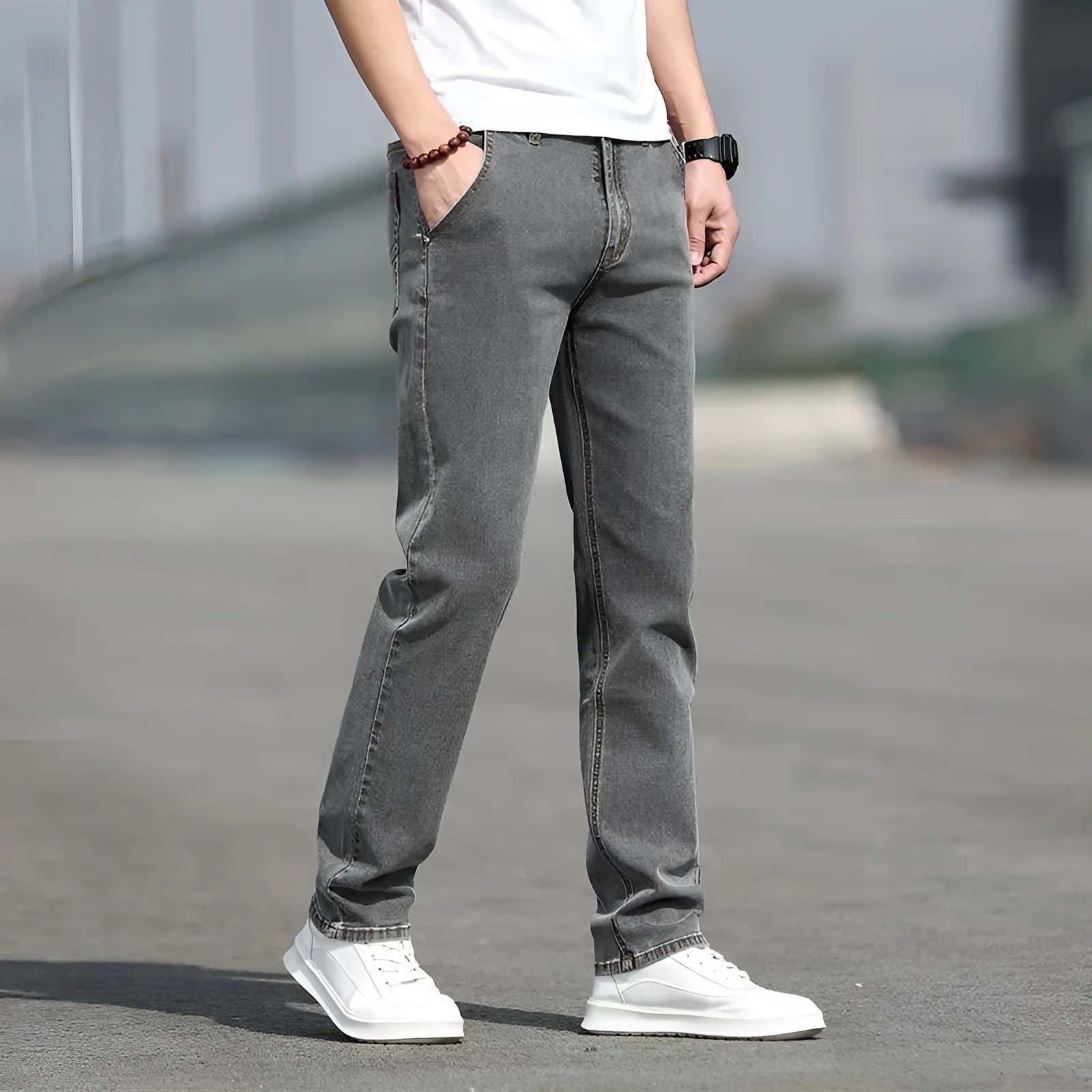Man wearing smoky grey straight leg men's jeans with a low waist and zip fly.