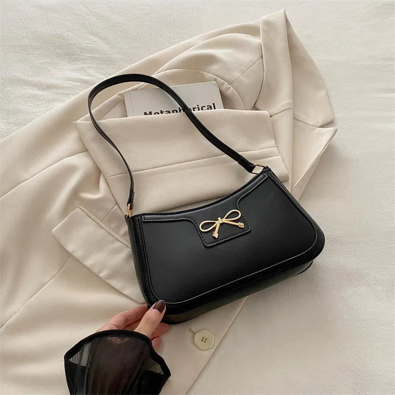 Western style PU leather shoulder bag with bow detail in horizontal square shape.