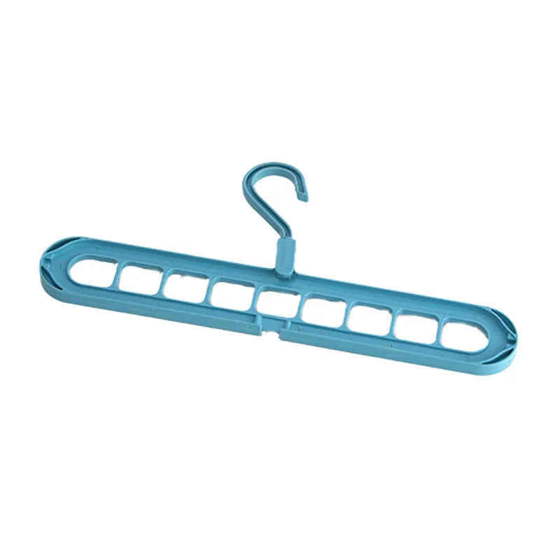Green plastic multifunctional hanger with nine arms for folding trousers, shown hanging on a rail.