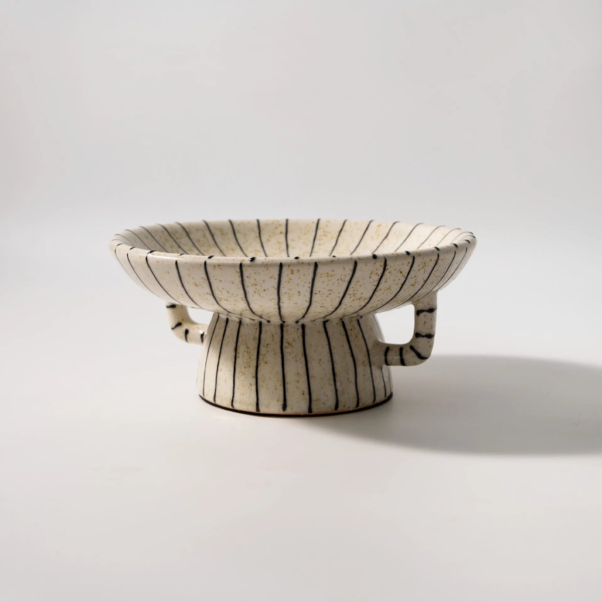 Black and white striped resin fruit plate on a table for dessert serving.