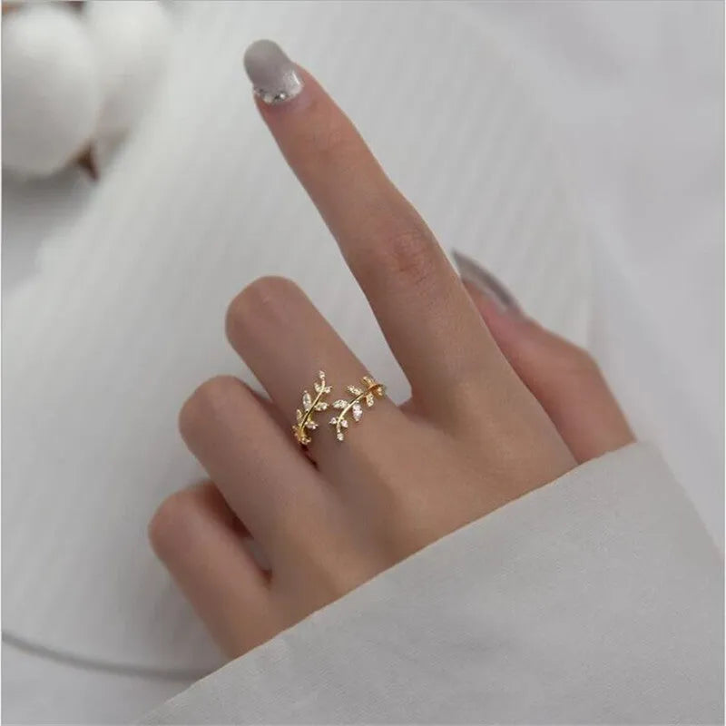 Gold and silver leaf-shaped branch ring for women on a white background.