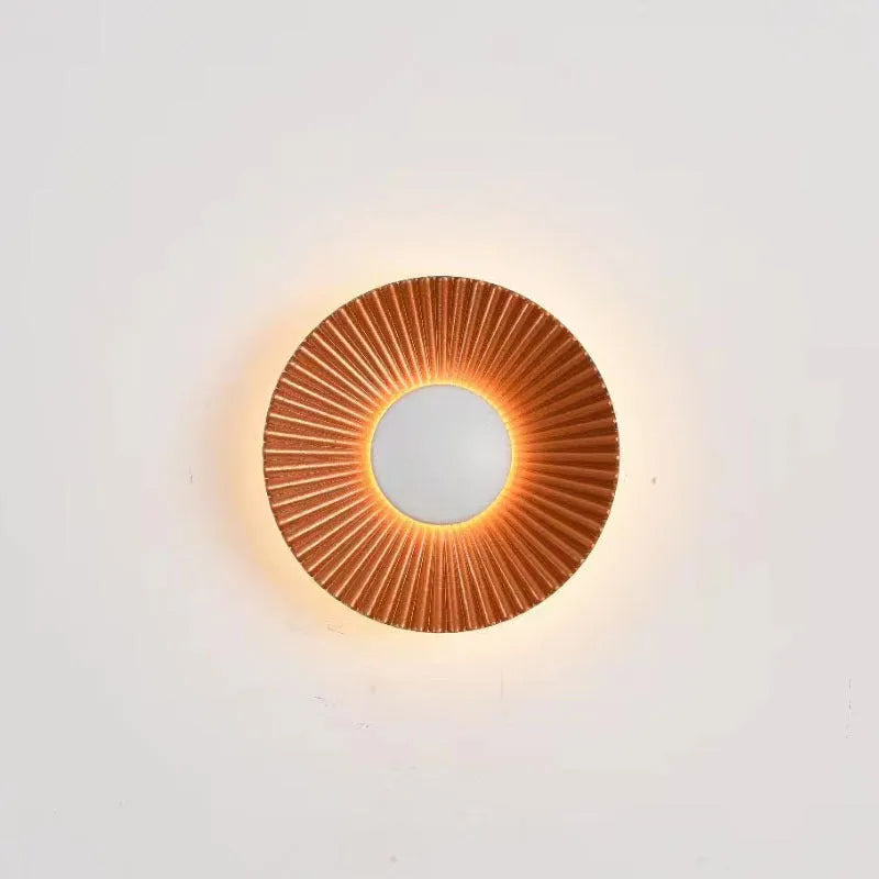 Round aluminium wall lamp with outer white and inner gold finish mounted on a wall