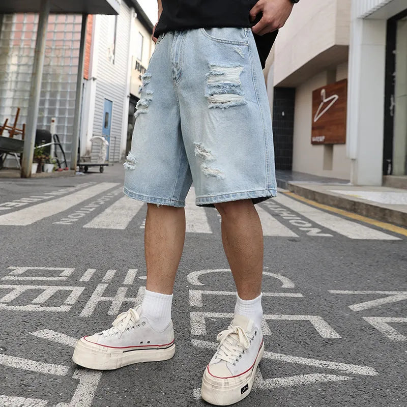 Light blue ripped denim shorts with distressed details and straight leg cut in hip hop streetwear style