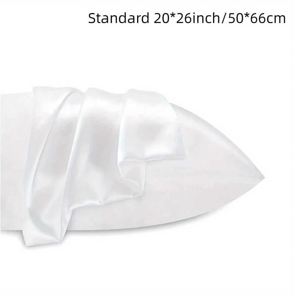 A pair of solid colour satin pillowcases in various colours and sizes on a bed.