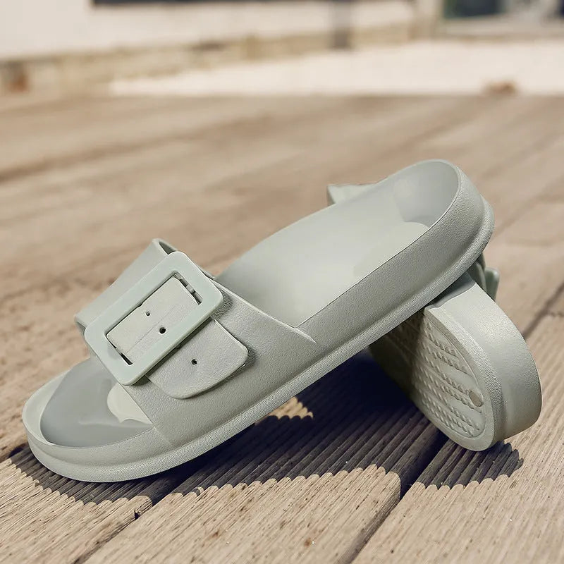 Women's grey blue EVA buckle slippers on a light background, showing the adjustable strap and textured sole.