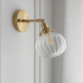 Pumpkin-shaped glass wall lamp with a curved shade on a wall, shown in water ripple transparent and solid blue glass options.