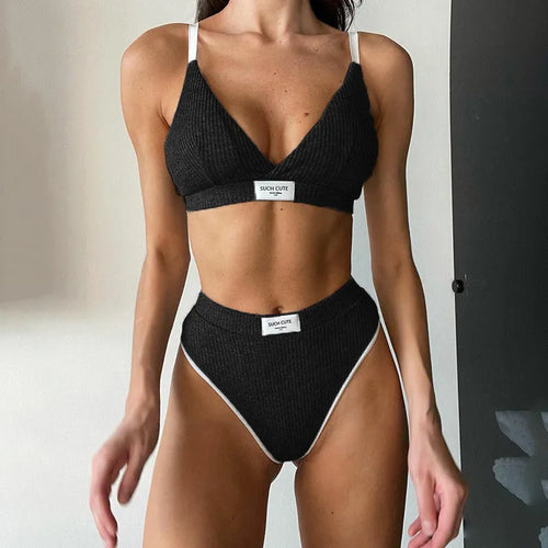 Women's black bikini set with white embroidery and contrast binding, showing sleeveless top and shorts.
