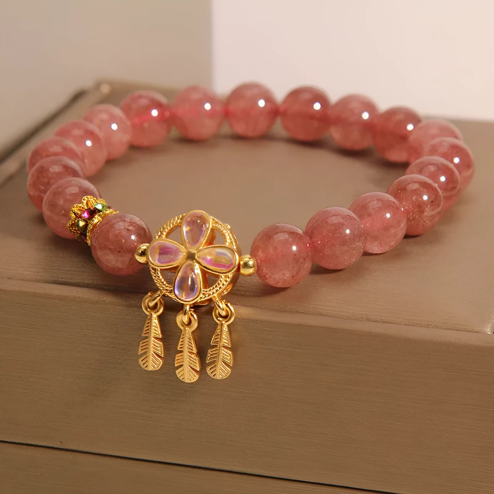 Women's strawberry quartz crystal bracelet with four leaf dream catcher ball pendant in natural rose pink colouration