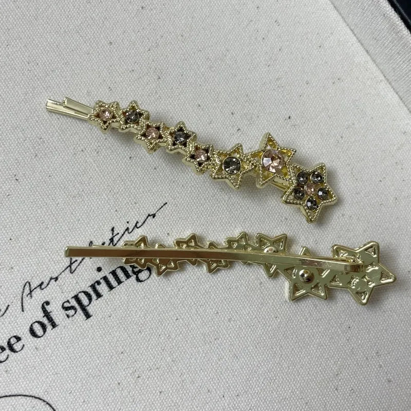 Gold electroplated alloy barrette with five-pointed star rhinestone design and broken clip construction