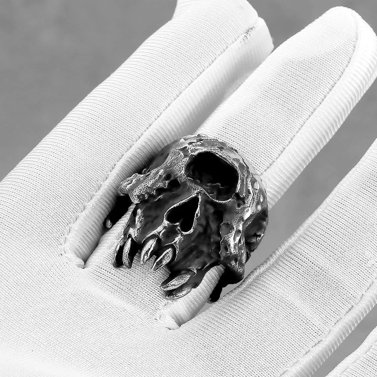 A close-up view of a silver-toned alloy ring featuring a detailed one-eyed skull design in a retro punk style.