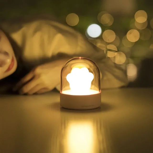 Grey and pink cat paw shaped USB rechargeable night light with adjustable brightness and musical rotation features