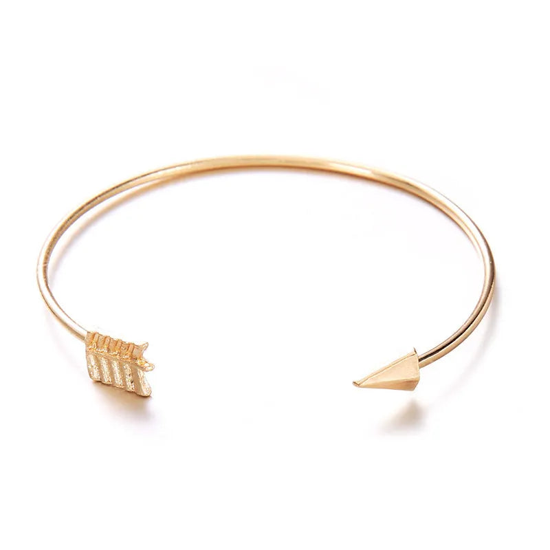 Gold-toned vintage women's cuff bracelet with an intricate arrow knot design.