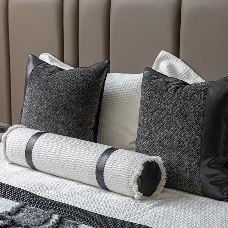 Grey and white plaid polyester bed runner blanket with matching pillowcase and leather round pillow on a double bed.