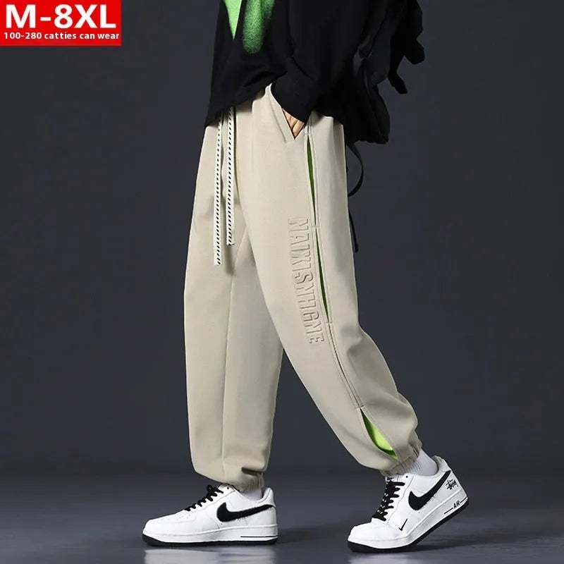 Man wearing loose grey-green trousers with stitching print detail and ankle banding.