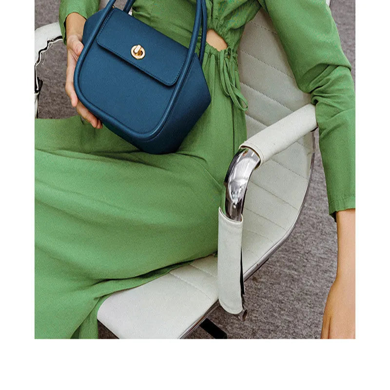 A soft cow leather wing-shaped tote handbag with a buckle and shoulder strap in black.