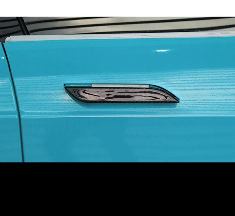 Four carbon fibre adhesive door handle protection stickers for Tesla Model S interior.