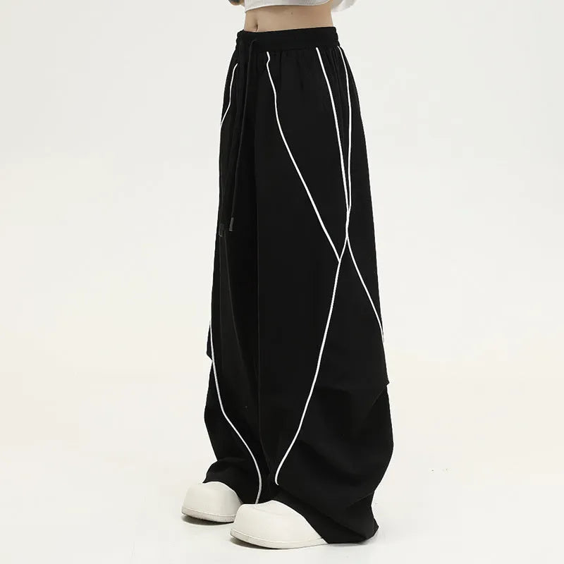 Black pleated hip hop wide-leg pants with stripe pattern showing mid-waist and loose fit