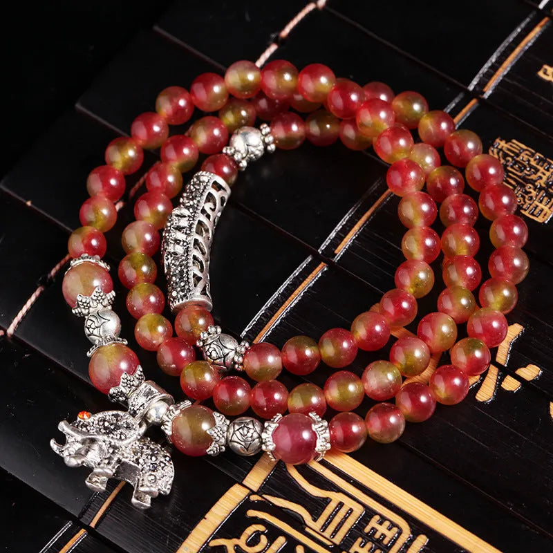 Handmade bracelet with a watermelon crystal elephant bead on a Chinese knot cord.