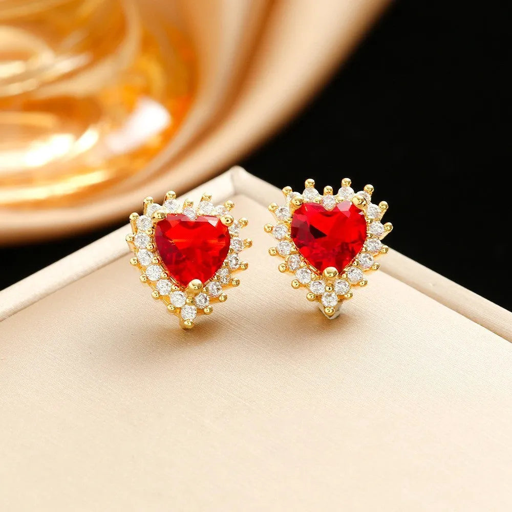 Gold red titanium steel heart jewellery set with gemstone inlay, showing necklace, earrings, and ring.
