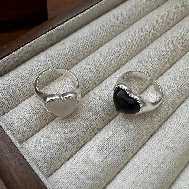 Adjustable open mouth sterling silver ring with a black agate heart on a silver band.