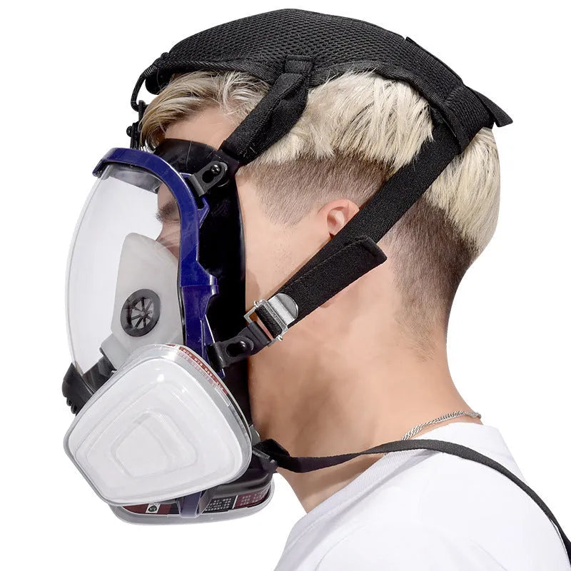Blue-edged spherical full-face gas mask with a trapezoidal filter canister on a white background.