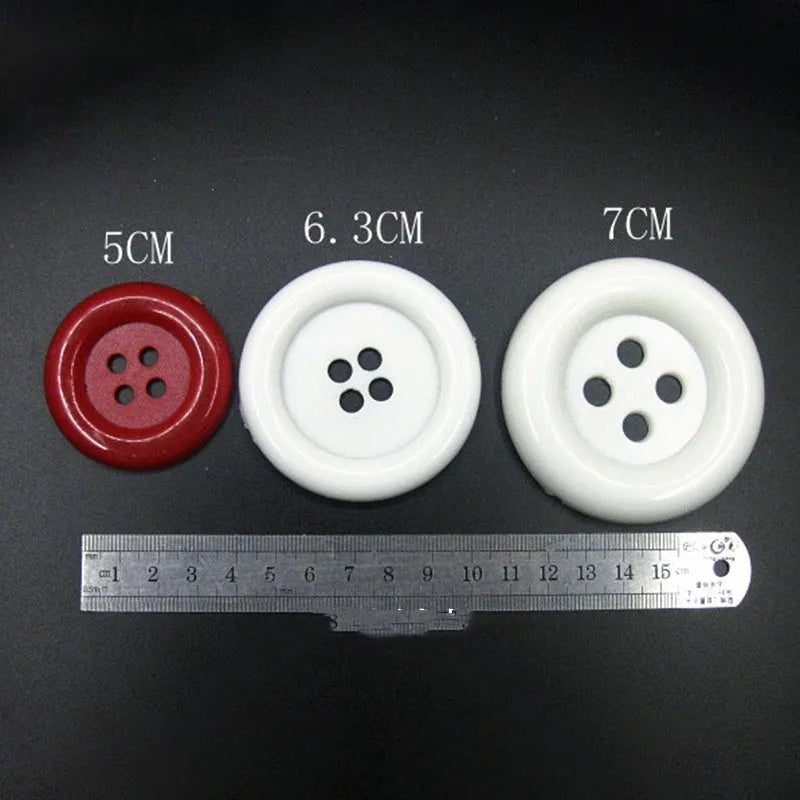 Oversized round plastic button with four holes in various colours and sizes from 38mm to 70mm.