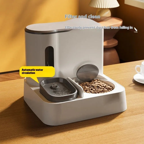 Grey automatic cat feeder and water dispenser station with integrated double bowls on a wooden floor.