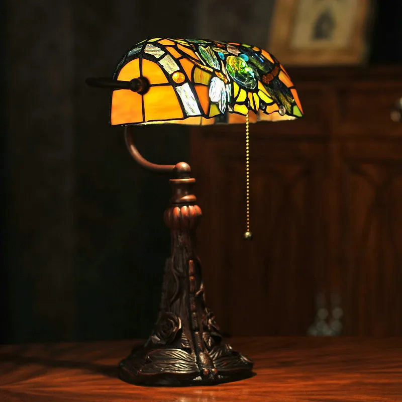 10-inch Tiffany desk lamp with coloured stained glass shade and resin base on a table.