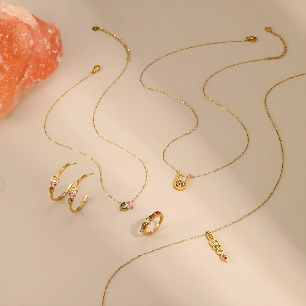Geometric gold-plated jewellery set showing necklace, ring, and earrings on stainless steel with 18K plating