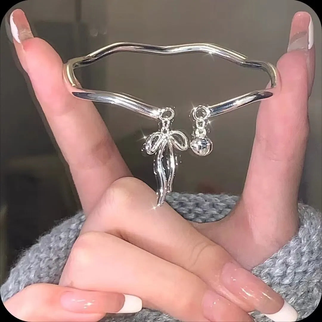Silver adjustable bracelet with bow charm and sliding clasp mechanism