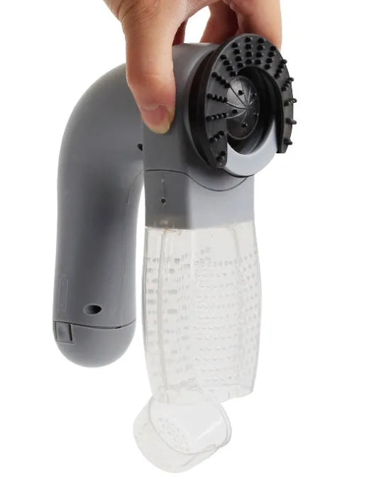 Grey portable pet hair vacuum cleaner with soft rubber head and large collection canister on a fabric sofa.